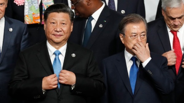 2019年6月28日，中国国家主席习近平与韩国总统文在寅在日本大阪举行的G20峰会期间合影。