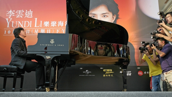 2006 年 10 月 29 日，來自中國大陸的世界級鋼琴家李云迪在香港海濱的首次戶外表演中被攝影記者 (R) 拍到。2(16:9)