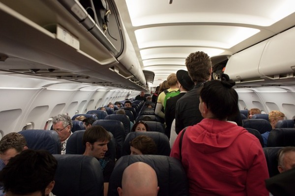 在坐飞机时有时会遇到其他乘客有不良行为。图为乘客在登机。