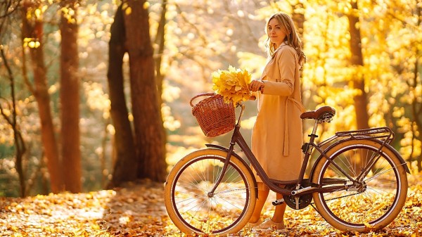 秋天公园里牵自行车的女人