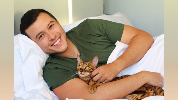一个男人和猫一起在床上