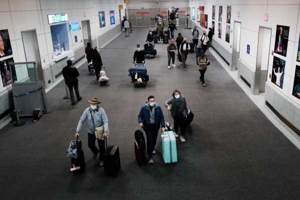 為了防止新冠病毒新變種“omicron”（奧米克戎）被傳播進入美國，拜登政府在考慮對所有入境美國的國際旅行者實施更嚴格的病毒檢測要求和隔離措施。圖為2021年11月30日，國際旅客抵達美國新澤西紐瓦克（Newark）國際機場。（圖片來源：Spencer Platt/Getty Images）