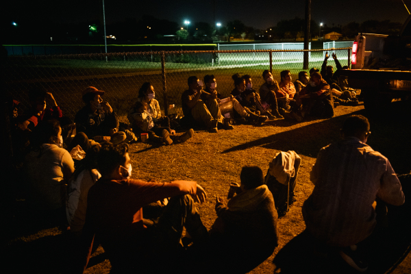 图为2021 年 11 月 17 日夜间，一群非法移民从美墨边境非法穿越格兰德河（Rio Grande）进入美国德克萨斯州的拉乔亚（La Joya），他们被美国边境巡逻队逮捕，在等待登上边境巡逻车被运送到边境处理中心。（图片来源：Brandon Bell/Getty Images）