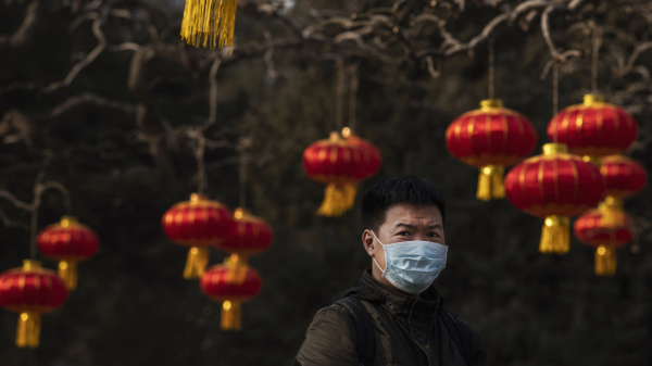 2020年1月25日的北京，一位男子走過為慶祝過年而掛起的燈籠。