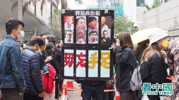 香港市民在法院外举牌要求释放政治犯。（图片来源：李天正/看中国）