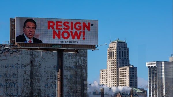 2021年3月2日，在纽约州州府阿尔巴尼的高速公路旁的广告牌在库默的照片旁写着：现在就辞职。（图片来源：Matthew Cavanaugh/Getty Image）