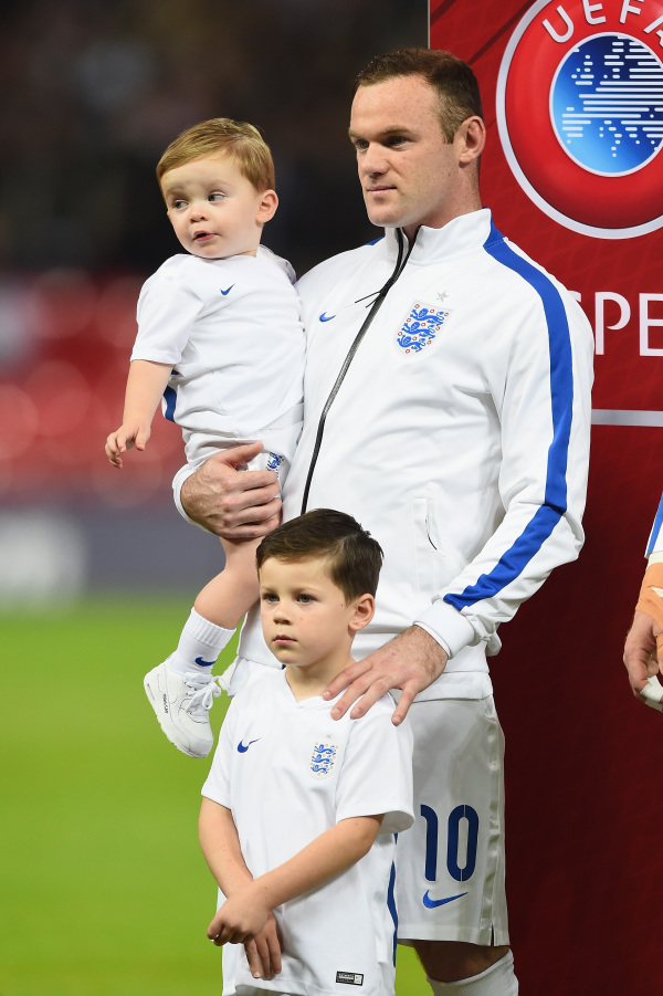 英国已退役的足球明星韦恩・鲁尼与他的孩子，Kai（底部）和Klay排队在英国伦敦的温布利球场。