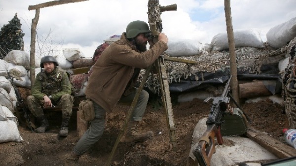 一名乌克兰军人通过潜望镜观察俄罗斯军队的动向。