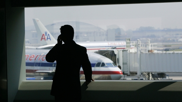 一個人在約翰·肯尼迪國際機場於2005年7月27日在紐約新的美國航空航站樓的手機上講話。