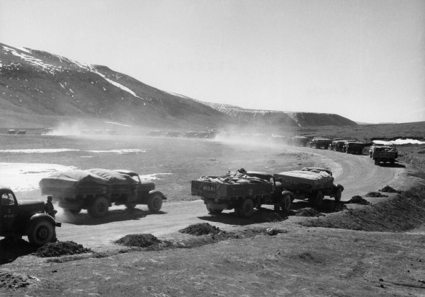 1965年8月拍摄的照片显示，卡车载着货物，沿着连接中国和西藏的新公路行驶。