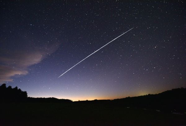 这是一张经过长时间曝光的图片，图中显示了SpaceX公司发射的一组星链（Starlink）卫星从南美国家乌拉圭上空掠过的轨迹，视角为美国佛罗里达州的某地。（图片来源：Mariana Suarez/AFP via Getty Images）