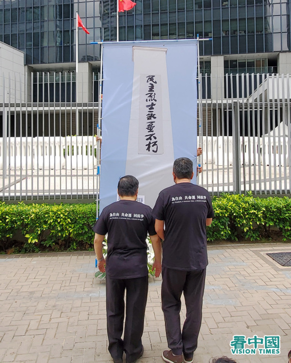 李卓人及何俊仁穿上印有“为自由 共命运 同抗争”的T恤，向“民主烈士永垂不朽”纪念碑三鞠躬悼念。（图片来源：李天正/看中国）