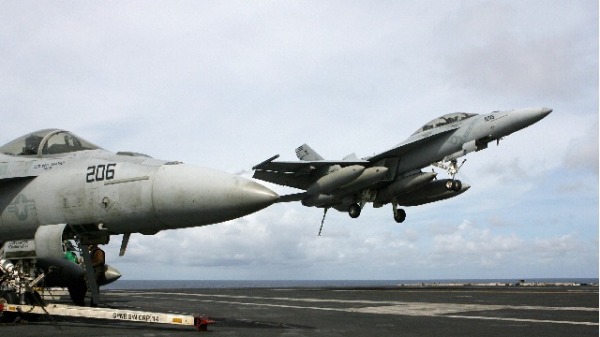一架美國空軍F-18戰鬥機正準備降落在一艘航空母艦的甲板上