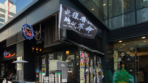 2019年香港沙田石門一間「黃店」門外掛著「光復香港 時代革命」的抗爭旗幟。（圖片來源：Wpcpey/wikipeida/CC-BY 3.0）