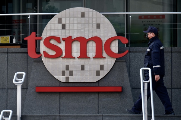2021年1月29日，一名保安人员在全球最大的半导体制造商台积电（TSMC）位于新竹的总部公司徽标前走过。