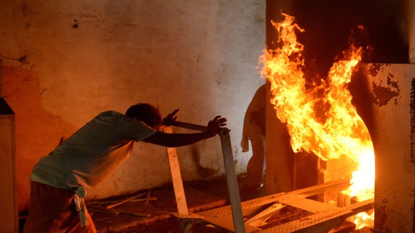 2021年4月27日，阿拉哈巴德一家火葬场员工正在进行火化工作。