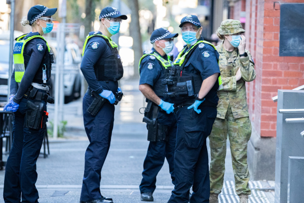 几名戴口罩的澳洲维多利亚警察和军官在洲际酒店外
