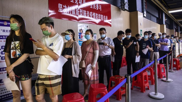 2021年 6月，武漢市居民戴著口罩在一個疫苗接種點接受 COVID-19 疫苗