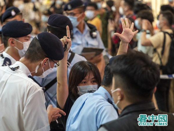 6月12日，在香港铜锣湾被截查的市民举起反送中五加一手势。（图片来源：李天正/看中国）
