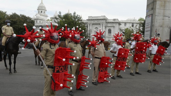 6月9日，印度海德拉巴（Hyderabad）一个交通路口，头戴Covid-19冠状病毒主题头盔和盾牌的警察在值勤。