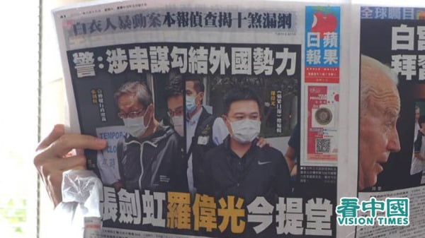有市民举起《苹果日报》6月19日报纸，在西九龙法院外声援壹传媒行政总裁张剑虹和《苹果日报》总编辑罗伟光。