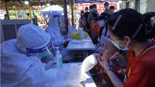 這張於 2021 年 5 月 30 日拍攝的照片顯示，一名兒童（右二）在廣東省廣州市接受 Covid-19 冠狀病毒核酸檢測。(16:9)