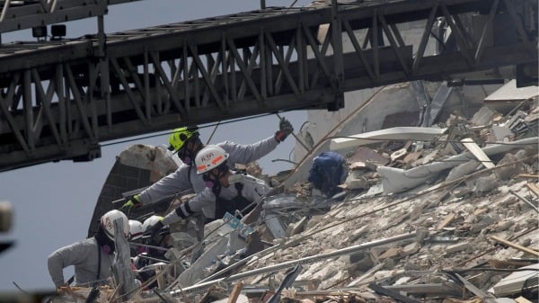 2021年6月25日，美国佛州迈阿密附近一栋12层海滨公寓大楼尚普兰塔（Champlain Towers South）的一部分倒塌后，搜救人员在搜救。（图片来源：Joe Raedle/Getty Images）