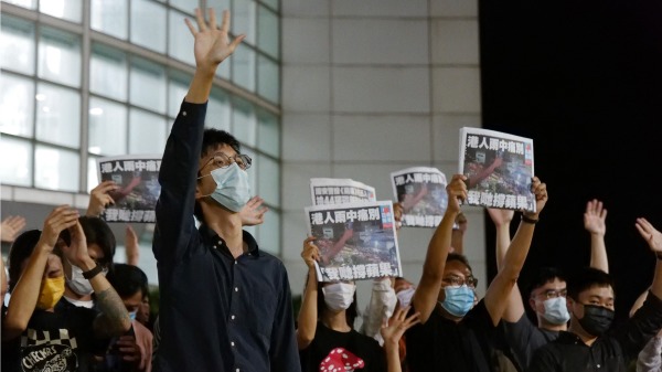 6月24日，《蘋果日報》員工舉起最後一期出版的報紙。（圖片來源：DANIEL SUEN/AFP via Getty Images）
