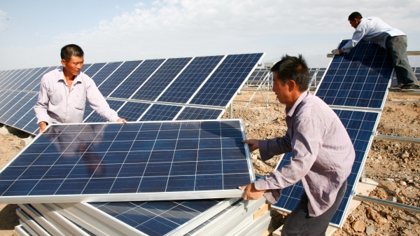 图为2011年8月22日，中国新疆哈密市，建筑工人在哈密太阳能发电站安装太阳能板。（图片来源：VCGVCG via Getty Images）2(16:9)