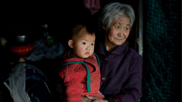 河北省承德镇一名妇女带着她的一个孙子在家中。