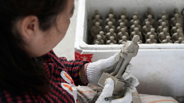 2021年5月27日，湖南韶山的一名工人正在检视生产的毛泽东小雕像。中共在建党百年前大力加强政治宣传。