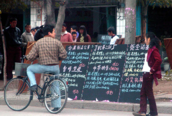 路人在中国东南部福建省福州的一家职业介绍所外查看公告牌，主要提供附近工厂的工作。