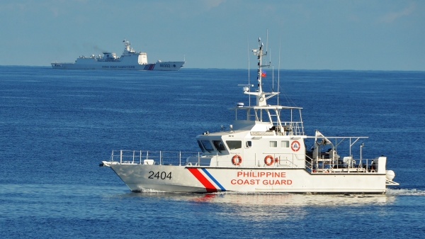 2019年5月14日，一艘菲律賓海警船和美國在南中國海進行聯合搜救演習時，遠處有一艘中共海警船在進行監視活動。（圖片來源：TED ALJIBE/AFP via Getty Images）