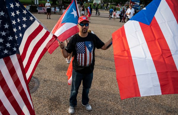 图为2021年7月18日，美国华盛顿特区白宫外面，一名男子手持美国国旗和古巴国旗，声援古巴的反共抗议，呼吁美国总统拜登对古巴人员给以援助。