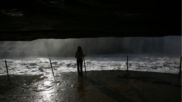 一名女子站在黄河壶口瀑布边，此为文章示意图。