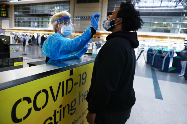 圖為在美國洛杉磯國際機場，旅客接受鼻拭子COVID-19測試。（圖片來源：Mario TamaGetty Images）