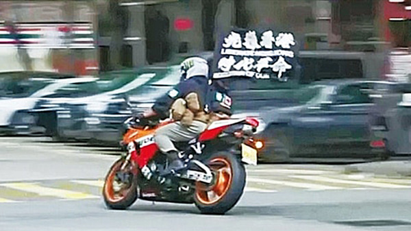 去年7月1日，唐英杰驾驶插有“光复香港 时代革命”旗帜的电自行车。（图片来源：网络截图）