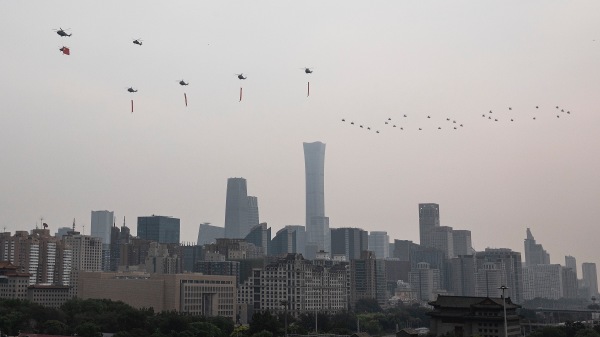 七一當天，中共軍機懸掛黨旗橫幅飛在灰濛濛的半空中（圖片來源：視頻截圖）