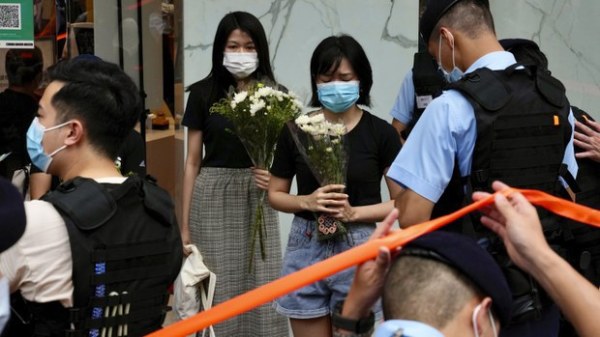 7月2日，港人在梁健辉刺警现场的铜锣湾手持白色鲜花。（图片来源：自由亚洲电台）