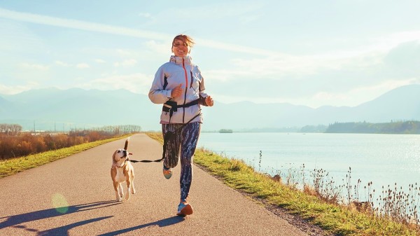 一个女人带小狗跑步运动