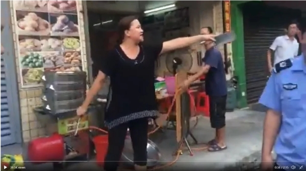 廣東一女店主手持雙刀與十幾個城管對峙的視頻近日在網路熱傳（圖片來源：視頻截圖）