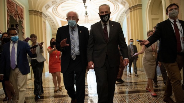 2021年8月9日，美国参议员桑德斯（左）和参院多数党领袖舒默（右）步入国会大楼（图片来源：BRENDAN SMIALOWSKI/AFP via Getty Images）