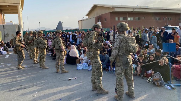 阿富汗人在阿富汗首都喀布尔军事机场排队等待登上撤离的美军航班