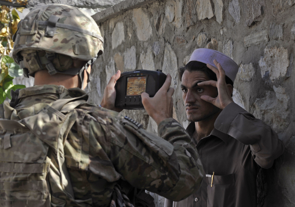图为2011年9月27日，在阿富汗和巴基斯坦交界处，一名美军在对一名阿富汗人扫描虹膜，生物数据存入自动生物识别系统（ABIS），以防备塔利班和其他恐怖组织的路边炸弹客。 