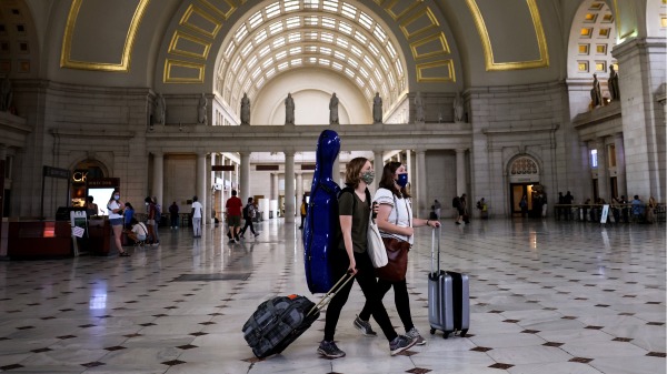 7月30日，民众戴口罩走过华盛顿特区联合车站。华盛顿特区规定，无论疫苗接种与否，民众室内必须戴口罩。