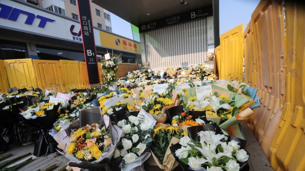 河南省鄭州市一個地鐵站前，民众獻花悼念水災遇難者。