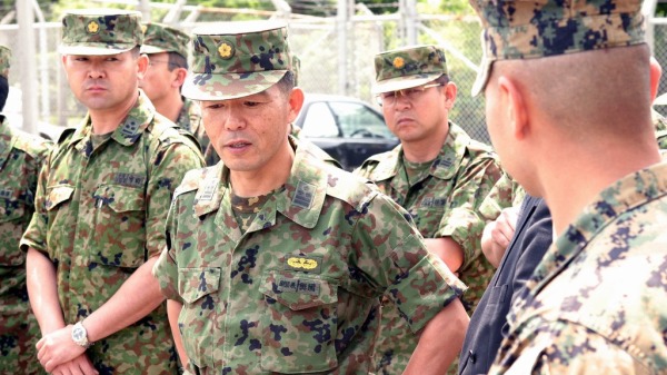 日本陆上自卫队副司令官（中）与美国海军陆战队等队员交谈。
