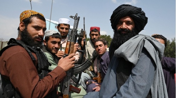2021年8月31日，塔利班战士坐在喀布尔机场的一辆皮卡车后面。
