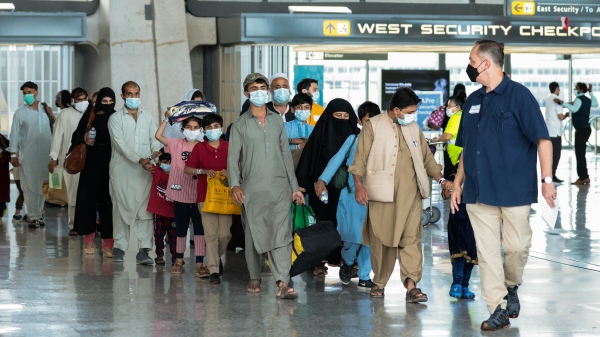 图为2021年8月31日，抵达弗吉尼亚州杜勒斯（Dulles）国际机场入境美国的一队阿富汗难民。 
