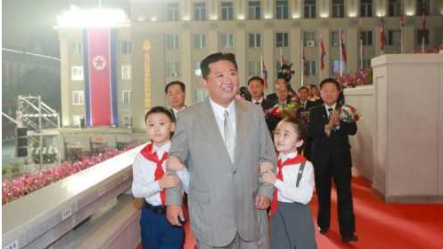 9日，朝鲜劳动新闻报导称，为迎接国庆73周年，金正恩国务委员长登上主席台，而少年团的儿童们挽着金委员长胳膊，以表示欢迎。